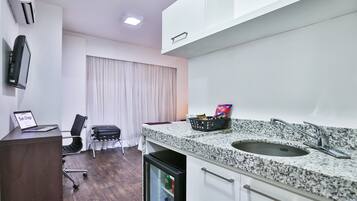 A modern kitchen with a granite countertop, a built-in sink, and a refrigerator.