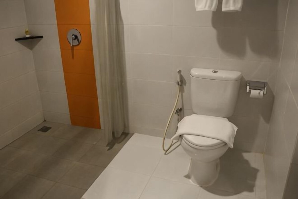 Un bagno con il water, una doccia e un porta asciugamani.