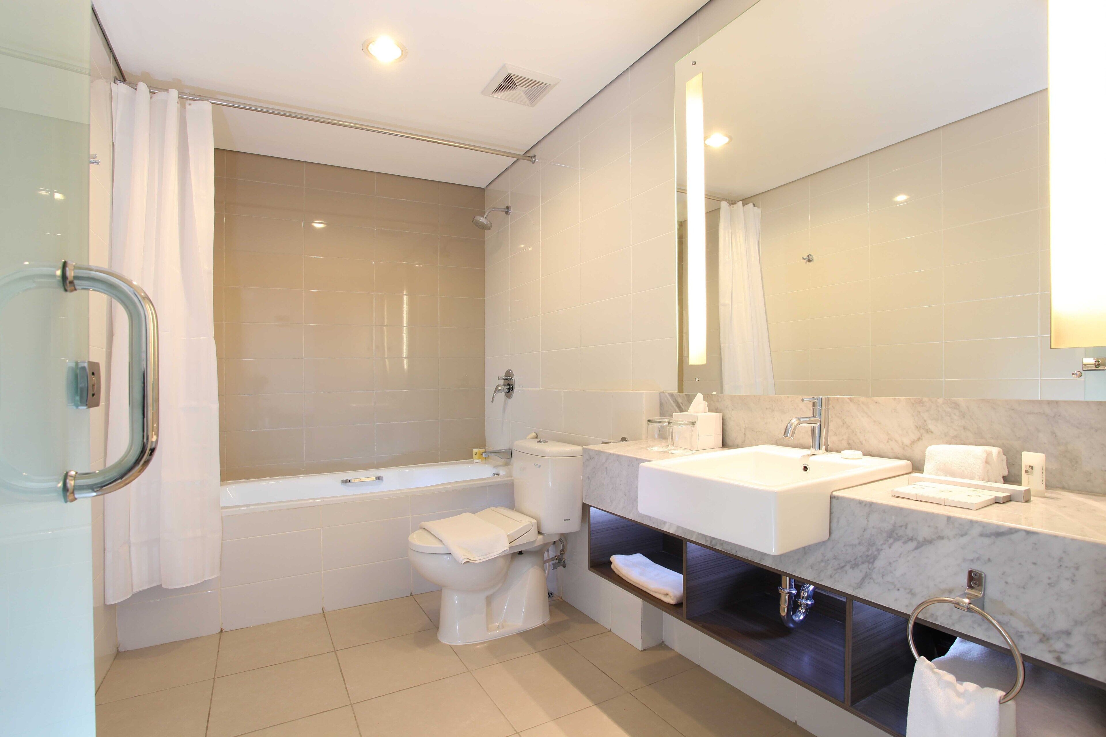 Ein modernes Badezimmer mit Badewanne, Toilette und zwei Waschbecken.