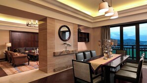 A modern hotel room with a dining area, a sofa set, a TV, and a large window offering a view. - Sheraton Changbaishan Resort (Baishan)