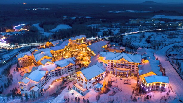 A snow-covered resort with multiple buildings, including a central lodge with a circular driveway. - Sheraton Changbaishan Resort (Baishan)