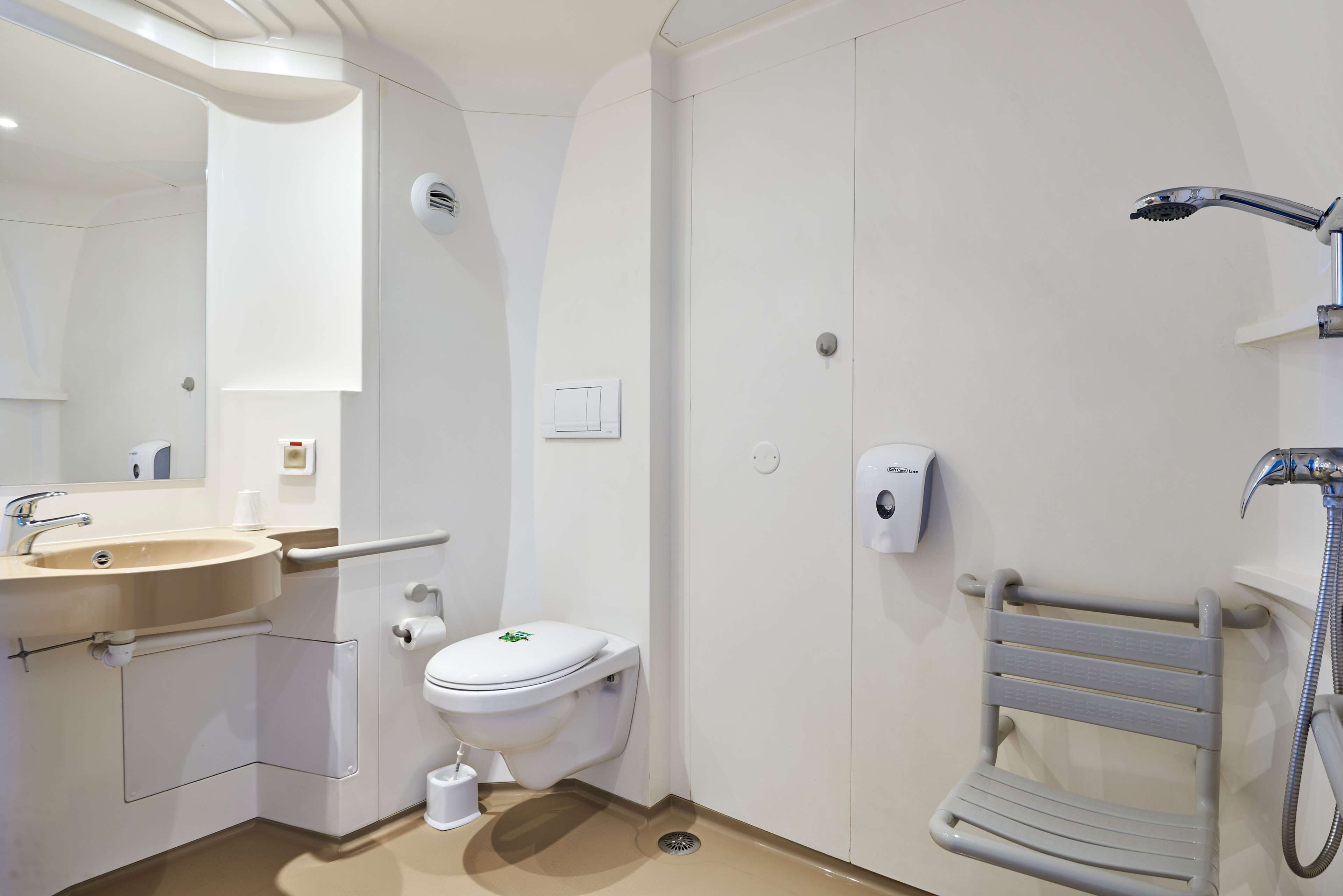 A modern bathroom with a sink, toilet, and shower.