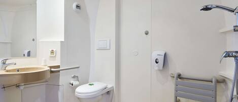 A modern bathroom with a sink, toilet, and shower.