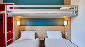 A bunk bed room with two beds, a red wardrobe, and a blue wall.