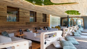 A modern spa with wooden walls, multiple seating areas, and a ceiling with hanging glass bubbles. - Saltria - your Alpine experience (Castelrotto)