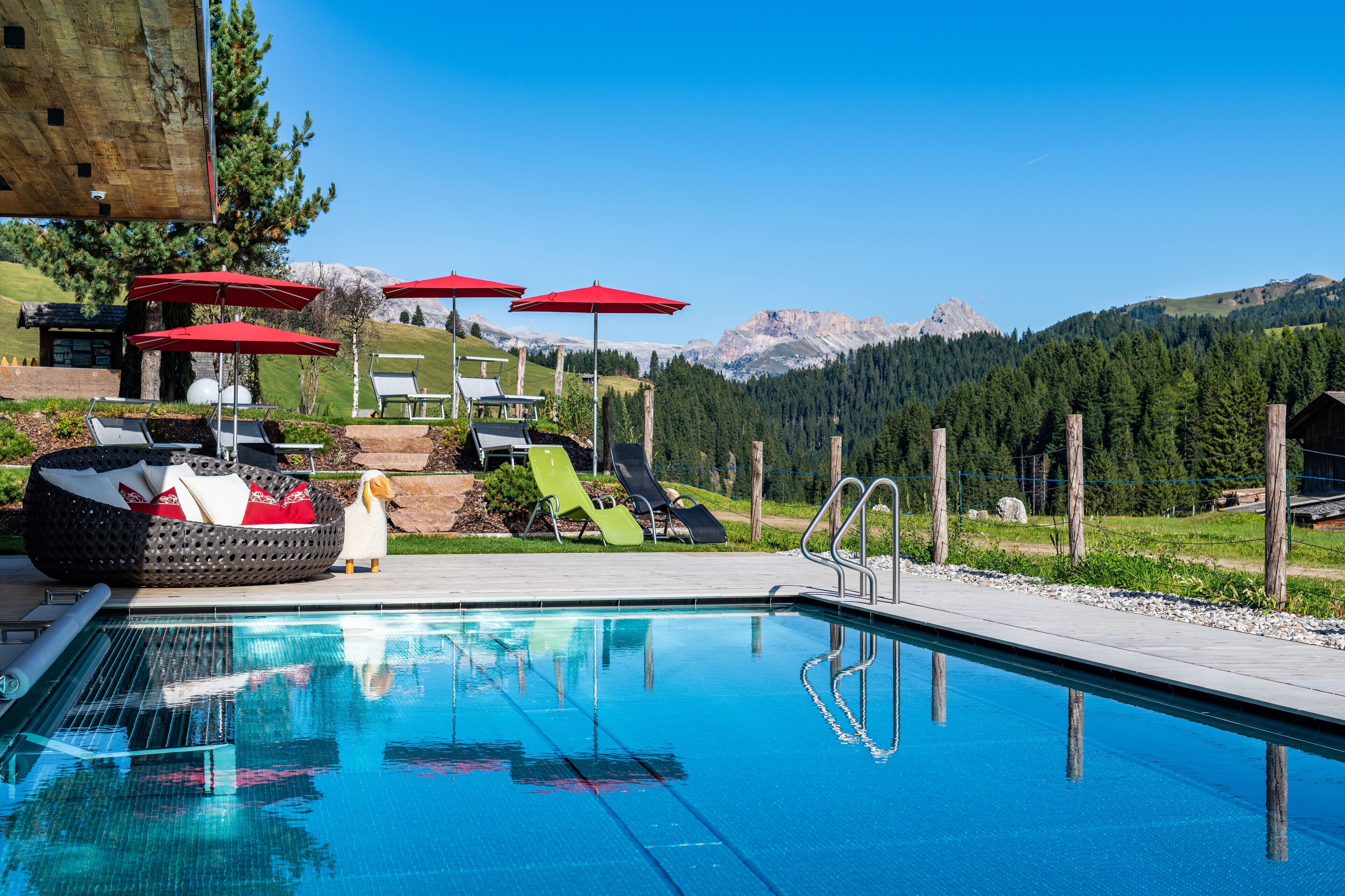 Una piscina techada, una piscina al aire libre, sombrillas