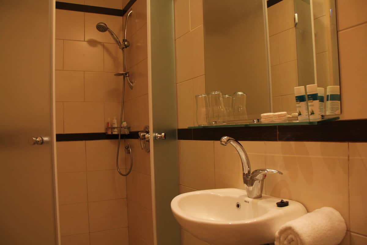 Une salle de bain avec un lavabo, un miroir et une douche.
