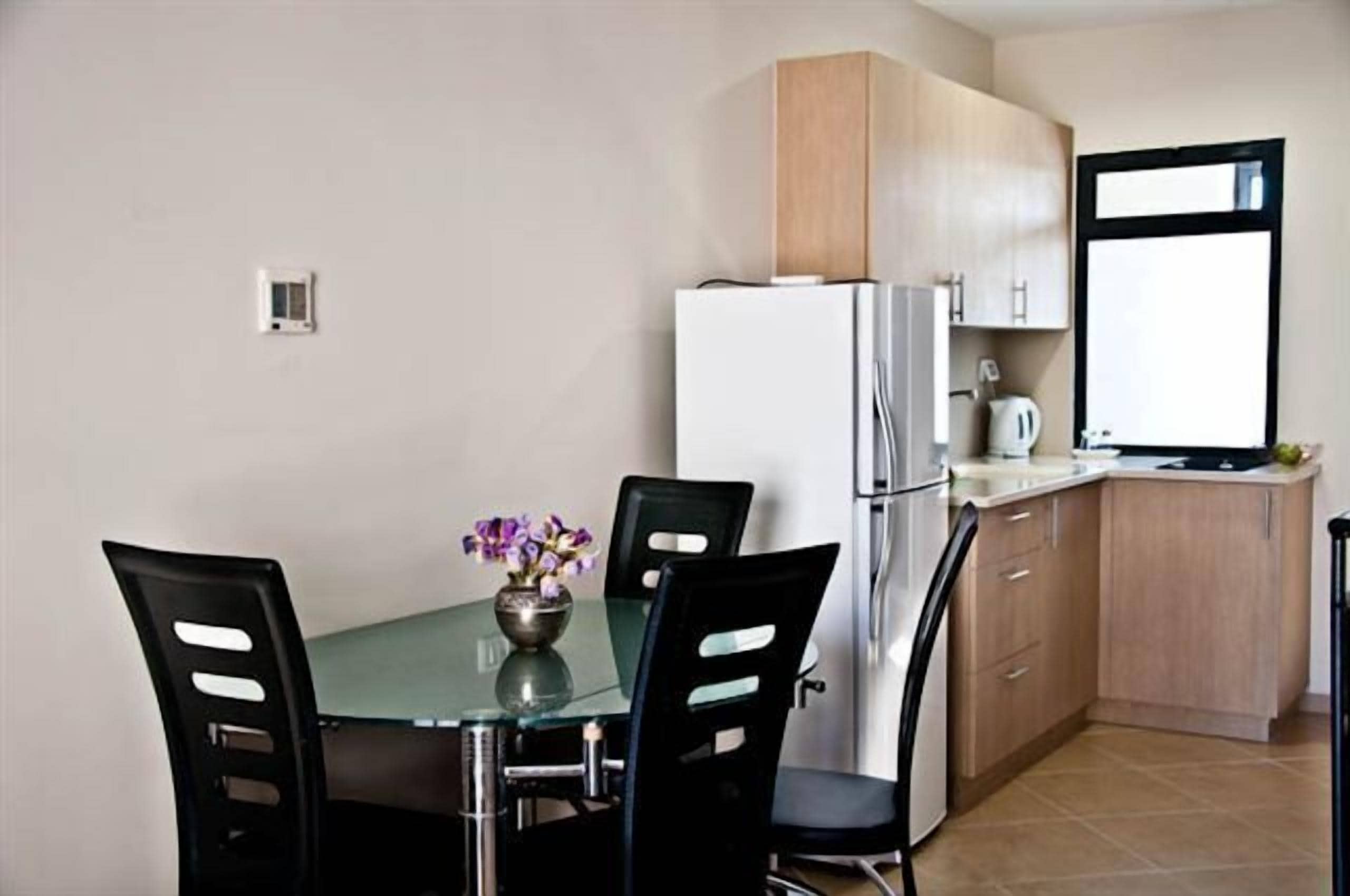 A compact kitchen with a refrigerator, a sink, and a window.