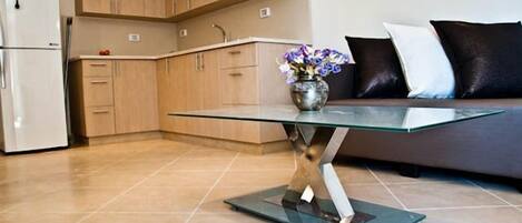 A modern kitchen with wooden cabinets, a glass table, and a vase of flowers.