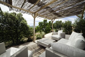 Relax in a shaded seating area with a view of the lush landscape.