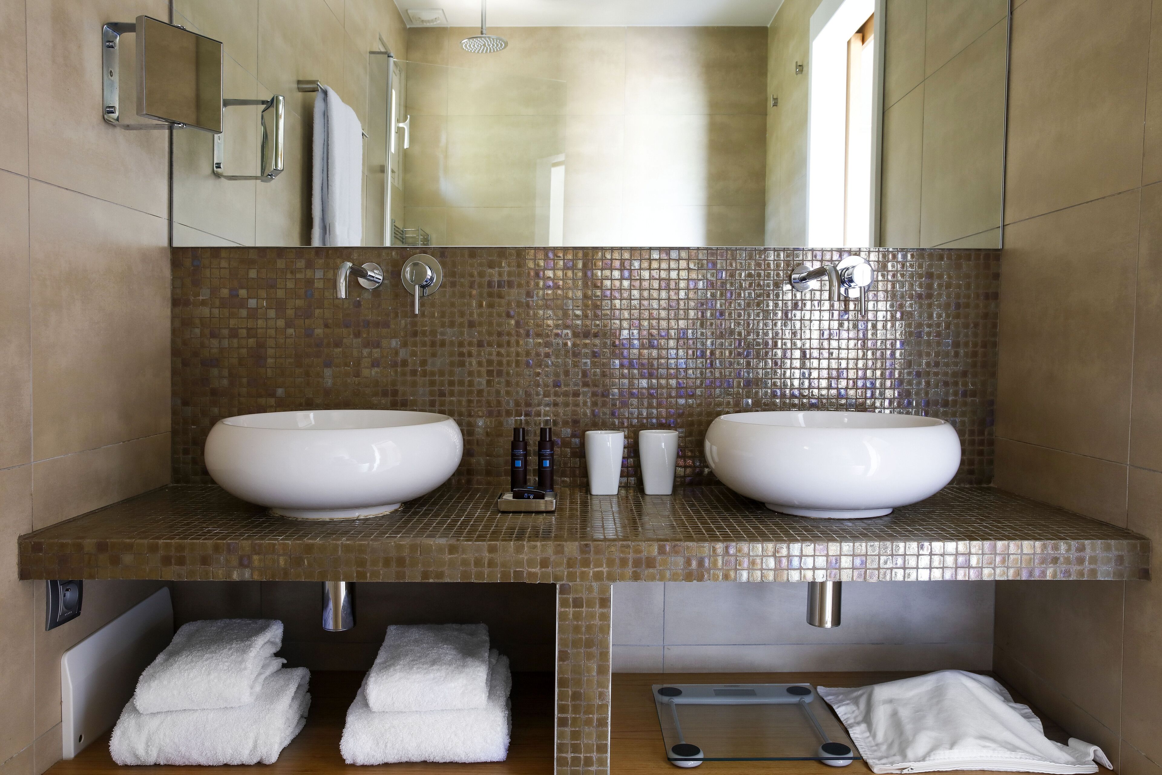 A modern bathroom with two large sinks, a mirror, and a shower.