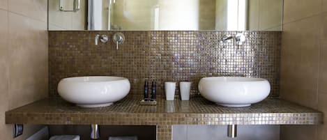 A modern bathroom with two large sinks, a mirror, and a shower.