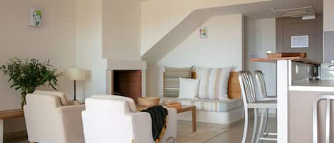 A modern living room with a sofa, chairs, a coffee table, and a fireplace.