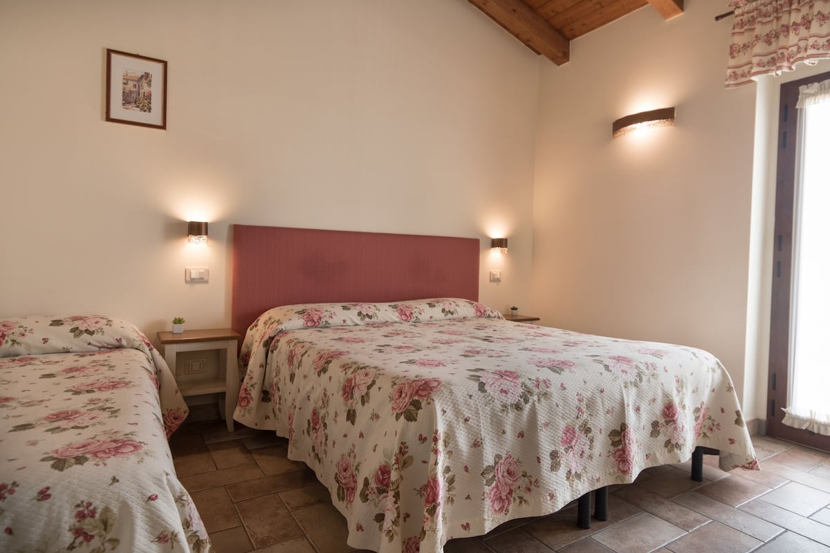 A bedroom with two beds, wooden headboards, and bedside tables.