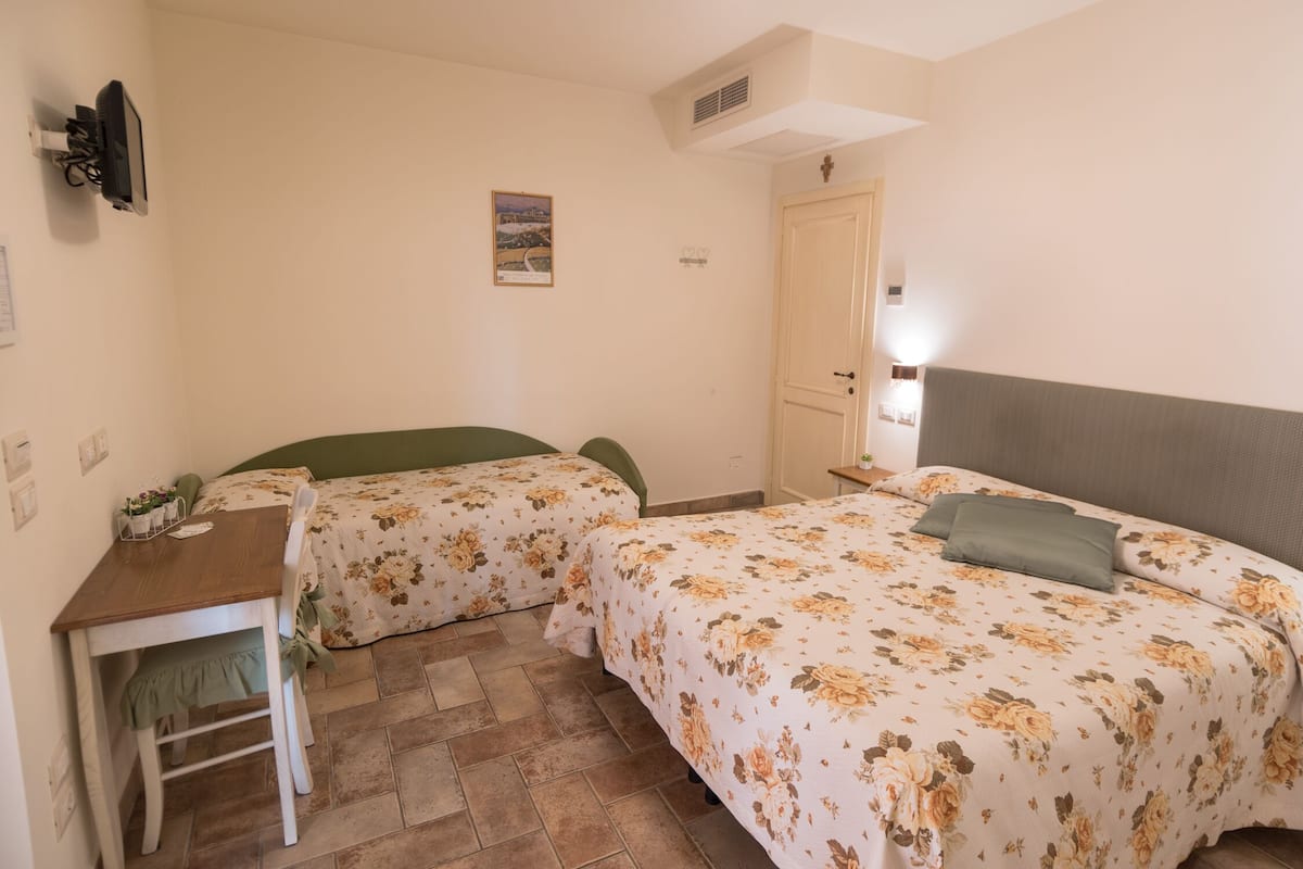 A room with two beds, a desk, and a chair.