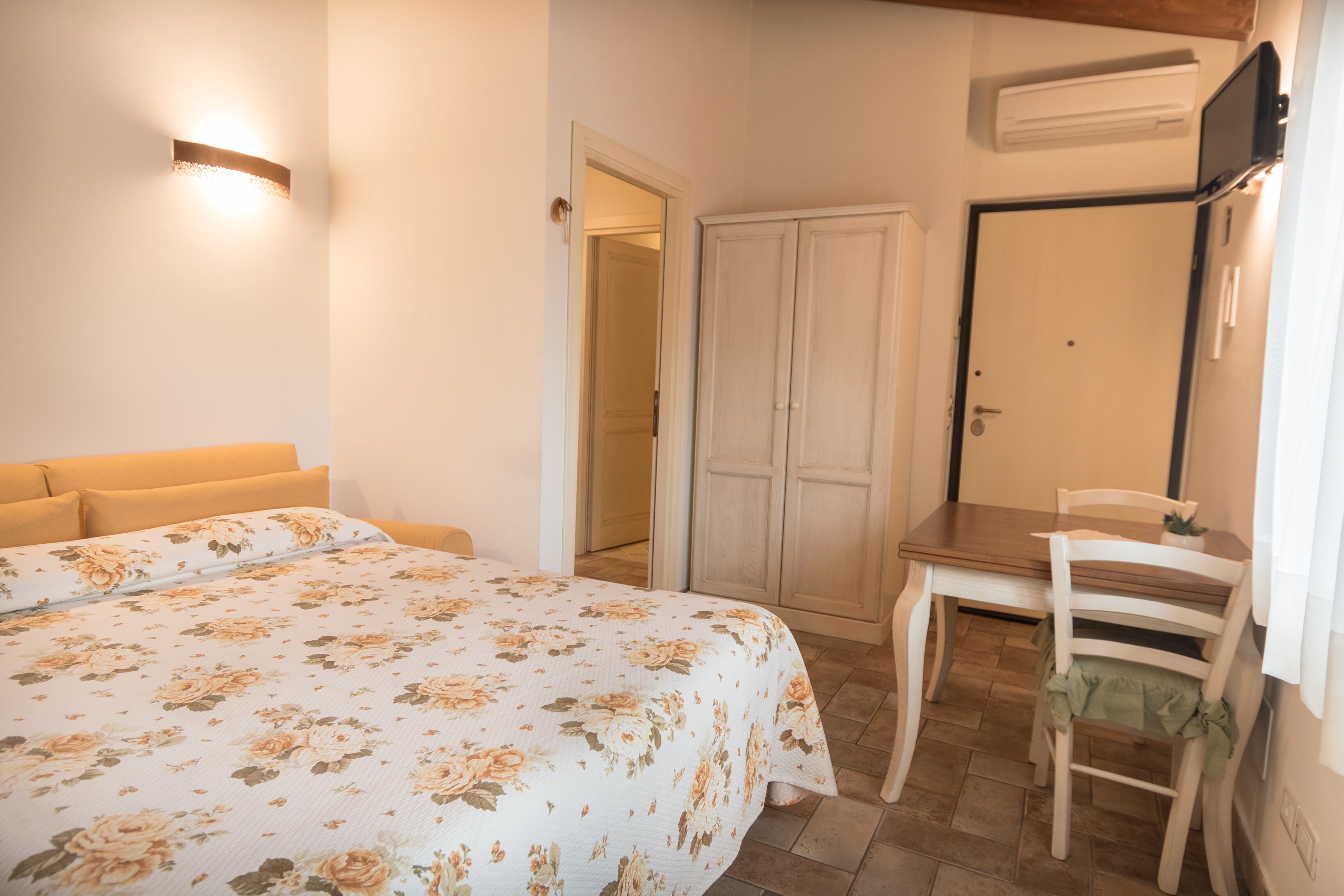 Ένα υπνοδωμάτιο με ένα κρεβάτι, μια καρέκλα, ένα γραφείο και μια ντουλάπα.