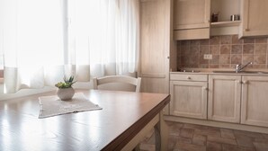 A kitchen with wooden cabinets, a countertop, and a sink. - Rosa di Assisi (Bastia Umbra)