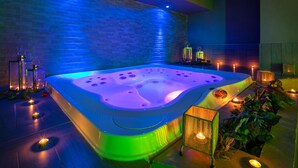 A spa area with a hot tub, candles, and a brick wall. - UmbriaVerde Sporting & Resort (Massa Martana)