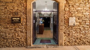 A stone-walled entrance with a sign reading "BYPILLOW" and a chandelier above. - BYPILLOW Cluc Begur (Begur)