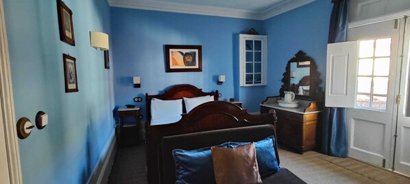 A bedroom with a bed, bedside table, dresser, and a window with curtains. - Casa da Avó - Turismo de Habitação (Torre de Moncorvo)