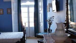 A bedroom with a bed, a dresser, a mirror, and a vase with decorative items.