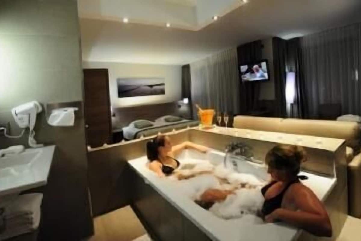 A modern bathroom with a bathtub, a sink, and a vanity.