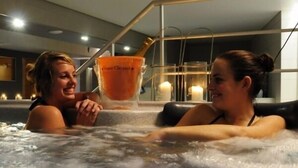 Two people in a hot tub with a bottle of orange juice. - Casino Hotel (Koksijde)