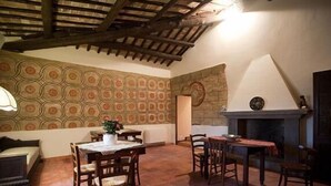Um quarto acolhedor com papel de parede estampado, lareira e mobiliário de madeira.