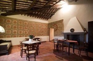A cozy room with a patterned wall, a fireplace, and wooden furniture.