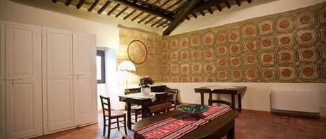 A dining area with a wooden table, chairs, and a patterned wall.