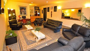 A living room with a sofa, armchairs, a coffee table, and a rug. - Hotel Amba Alagi (Mestre)