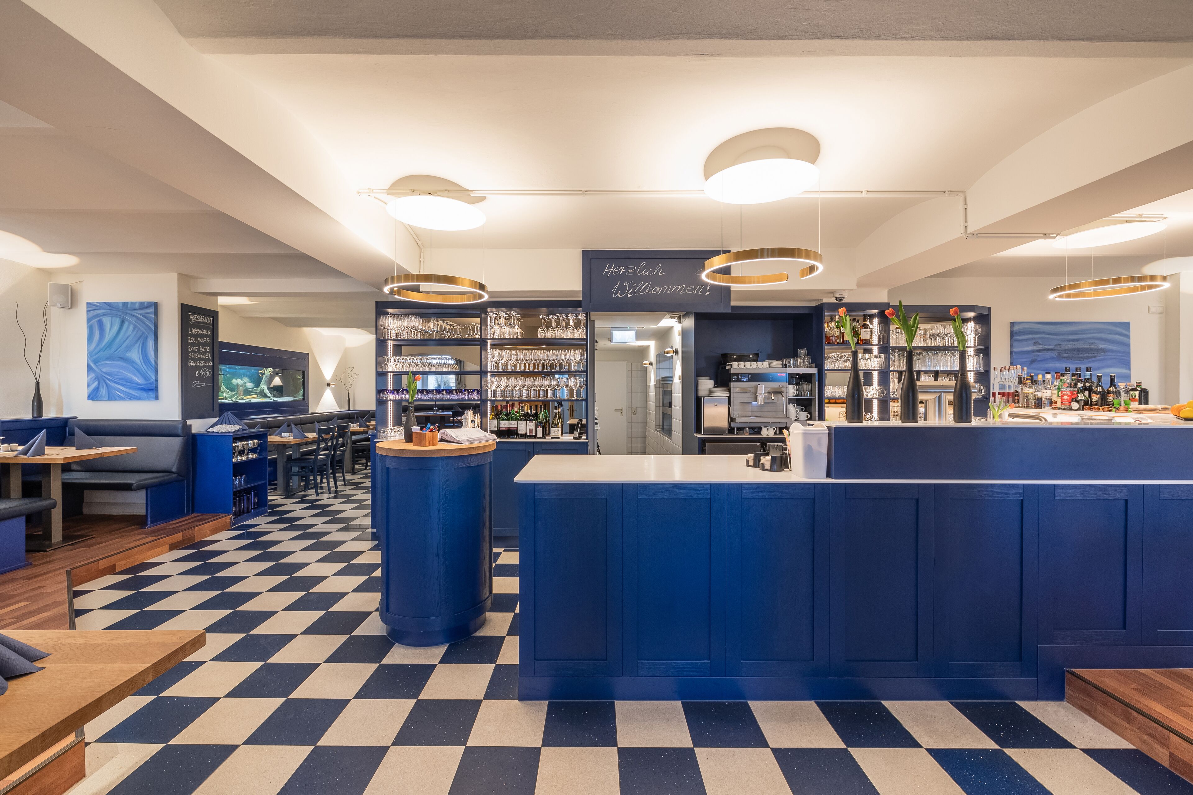 A bar area with a checkered floor, blue and white decor, and a counter with various items.