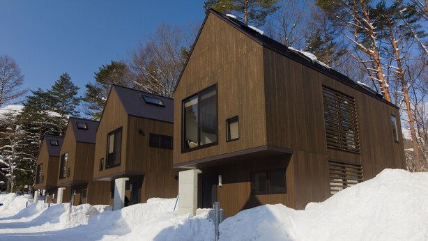 A row of modern wooden houses with large windows and a snowy landscape. - Gakuto Villas (Hakuba)