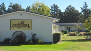 A building with a sign that reads "Cromwell Motel" and a large wheel feature.