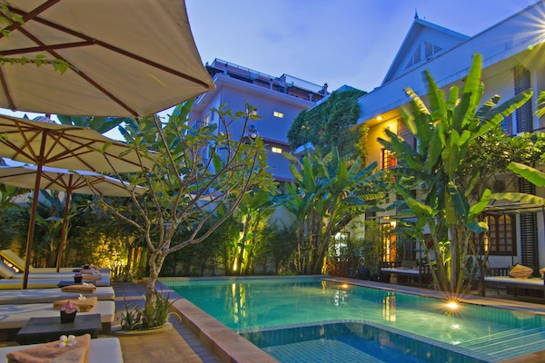 Una piscina al aire libre, camas de piscina gratis, sombrillas