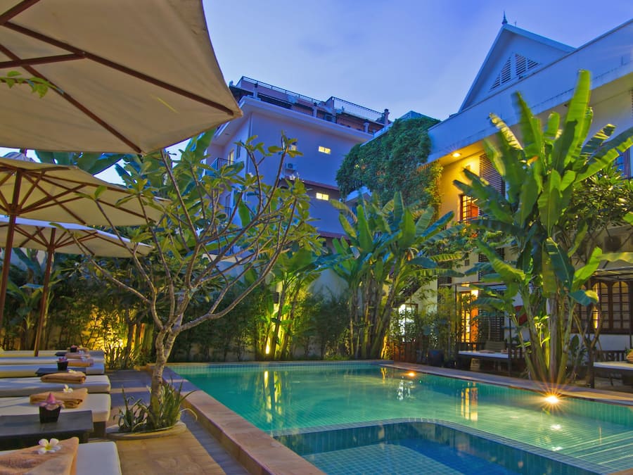 Una piscina al aire libre, camas de piscina gratis, sombrillas