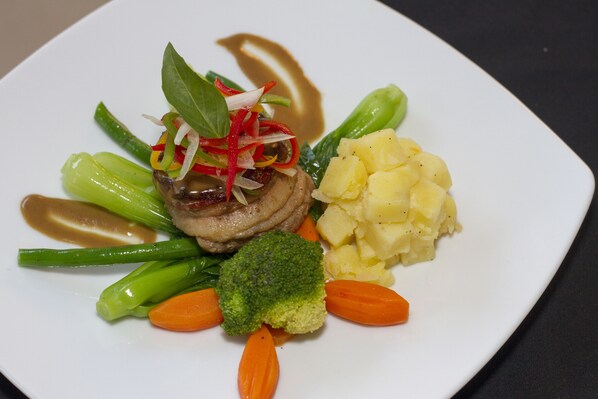 A plate of food with various vegetables and a piece of meat.