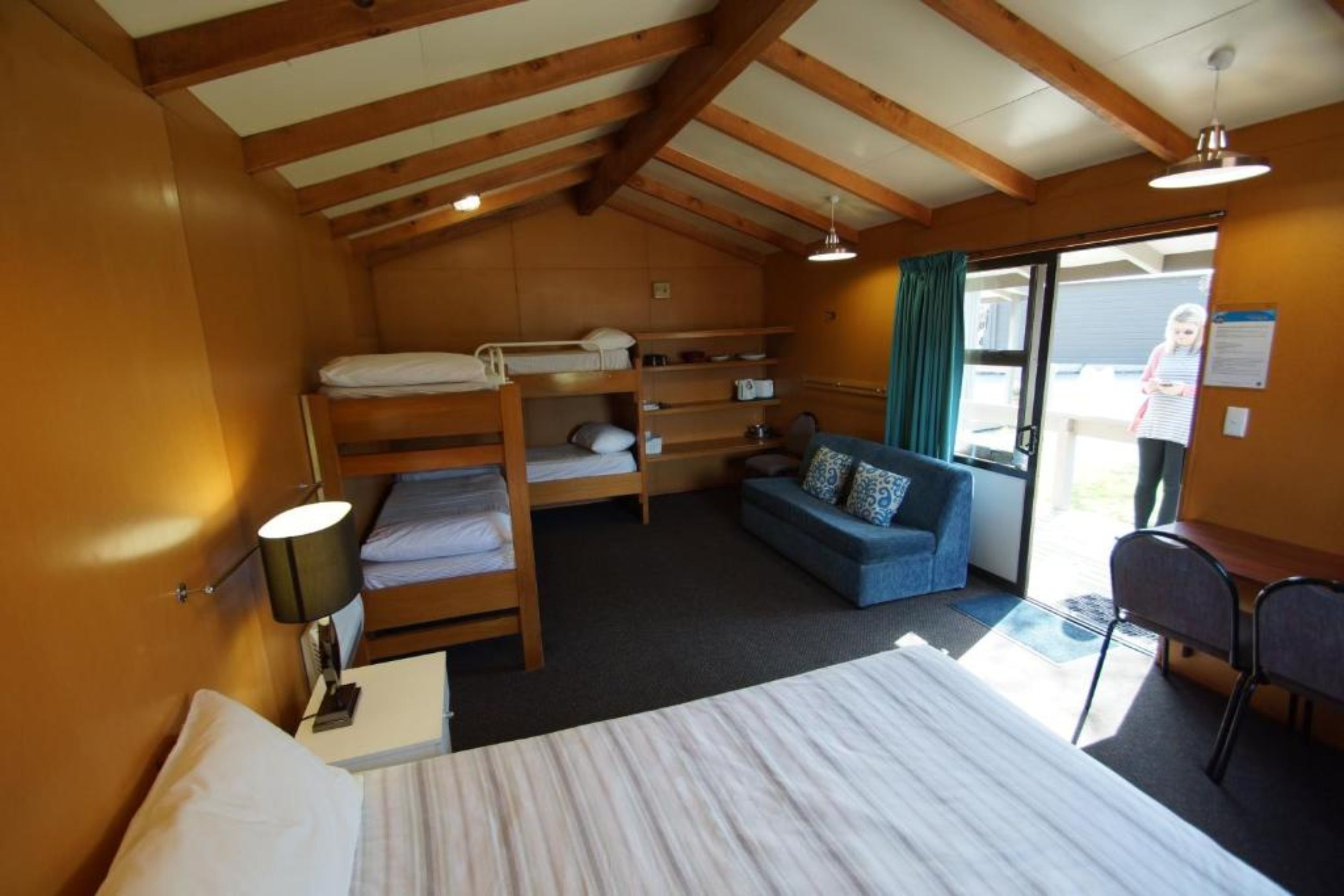 Ein gemütliches Zimmer mit Etagenbett, einer Schlafcouch und einem Schreibtisch.