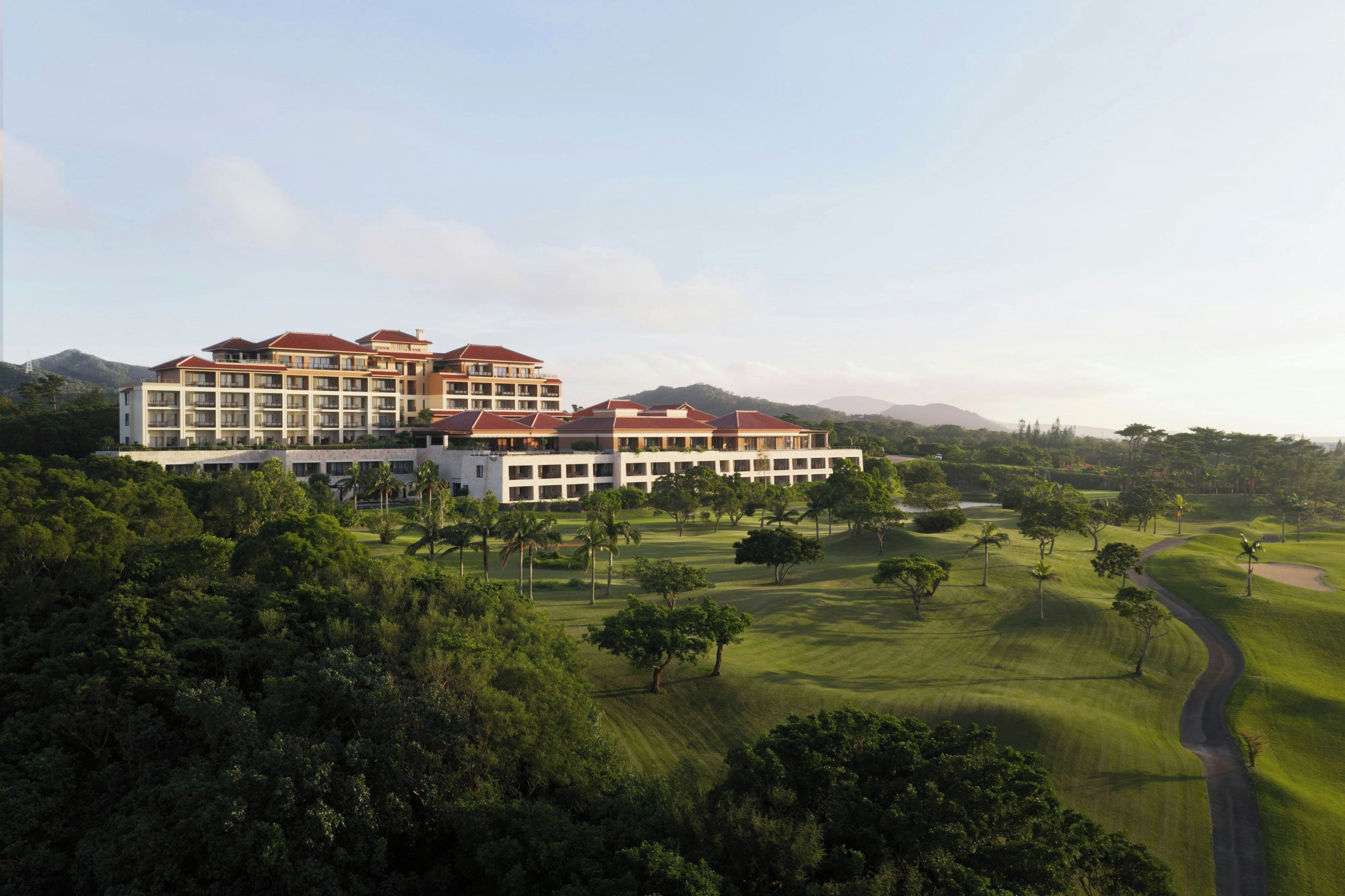 A multi-story hotel with a golf course in the foreground.