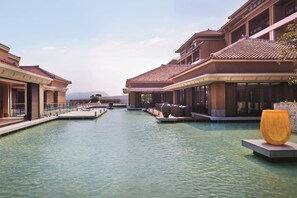 A resort with a central water feature, multiple buildings with balconies, and outdoor seating areas.