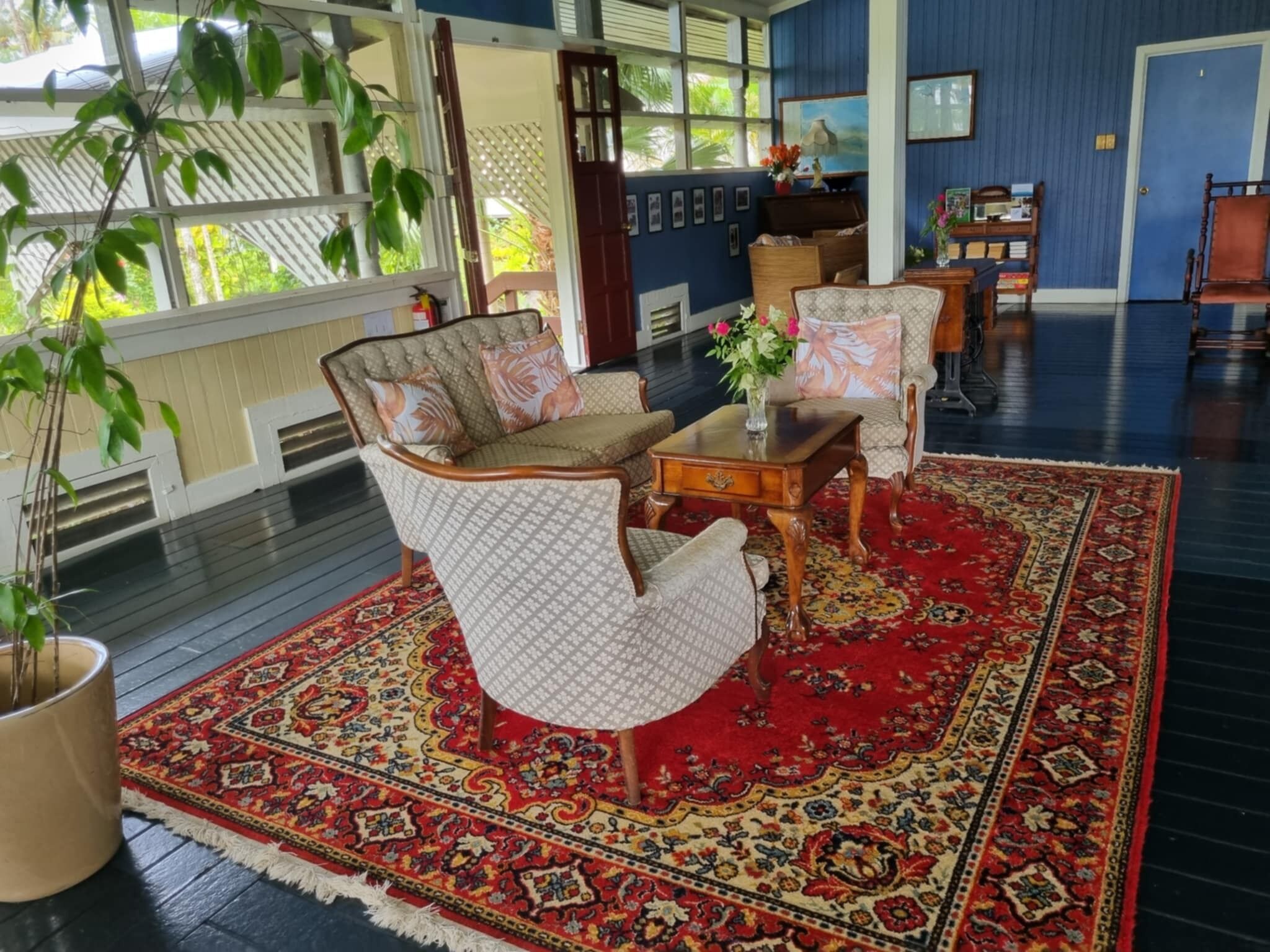 A room with a patterned rug, a sofa, and a chair.