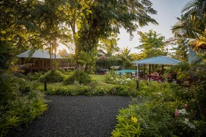 Un jardin luxuriant agrémenté d’un belvédère, d’une piscine et d’un espace salon extérieur.