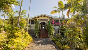 A hotel entrance with a covered porch, surrounded by lush tropical vegetation. - The Samoan Outrigger Hotel (Apia)