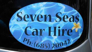 A car hire advertisement with the text "Seven Seas Car Hire" and a phone number.