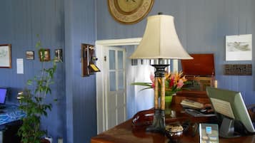 Una reception con una lampada, una pianta in vaso e un orologio appeso al muro.