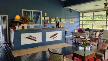A reception area with a blue counter, framed artwork, and a seating area with a bench and chairs.
