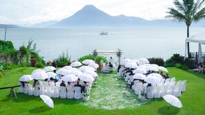 Une cérémonie de mariage qui se déroule sur une pelouse, avec en arrière-plan un lac paisible et une montagne.