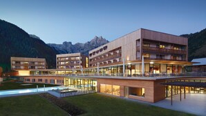 Ein modernes Hotel mit mehreren Etagen, Außenbereich und einem Pool.