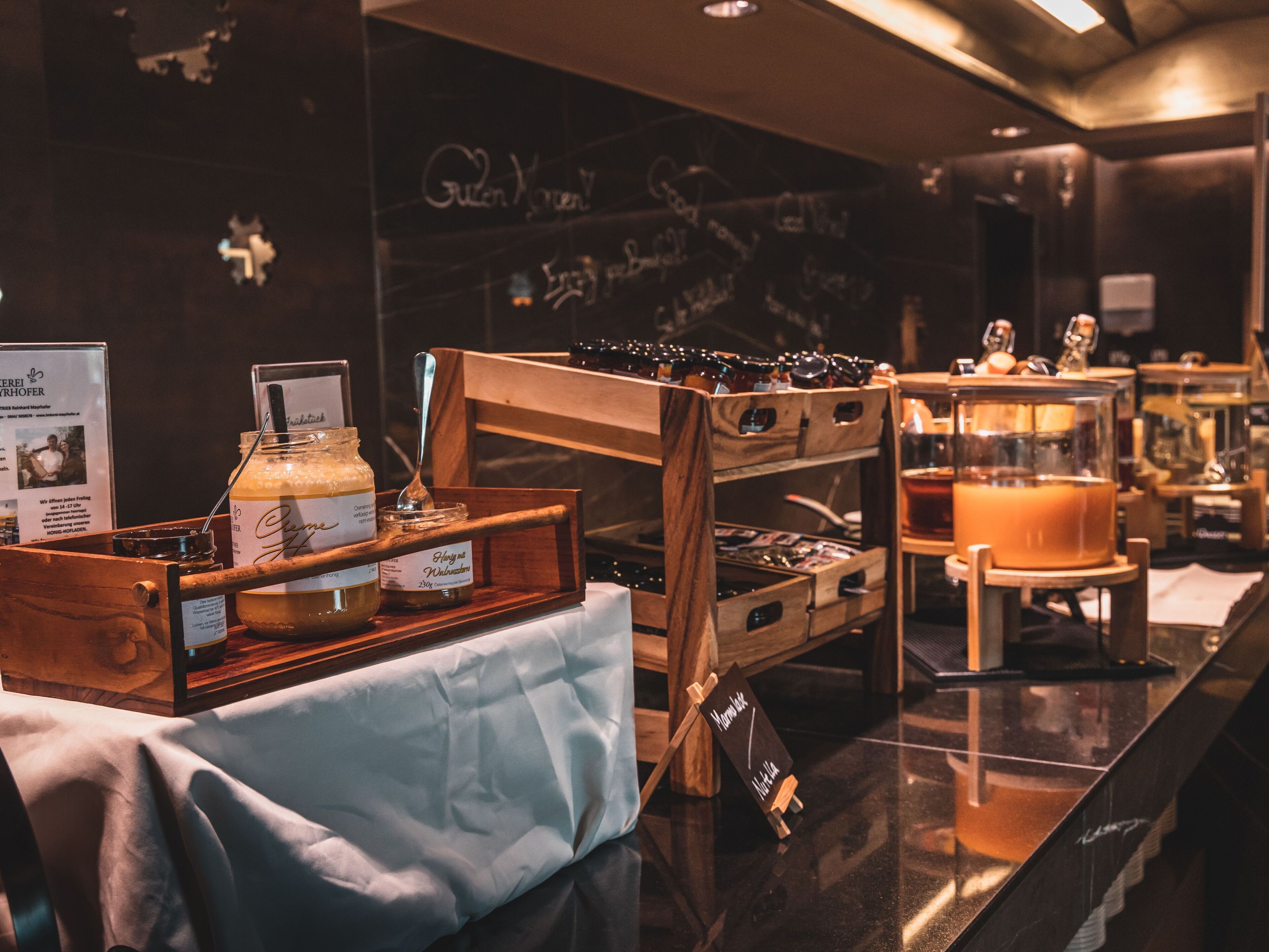 A buffet area with various food items and condiments displayed on wooden stands.