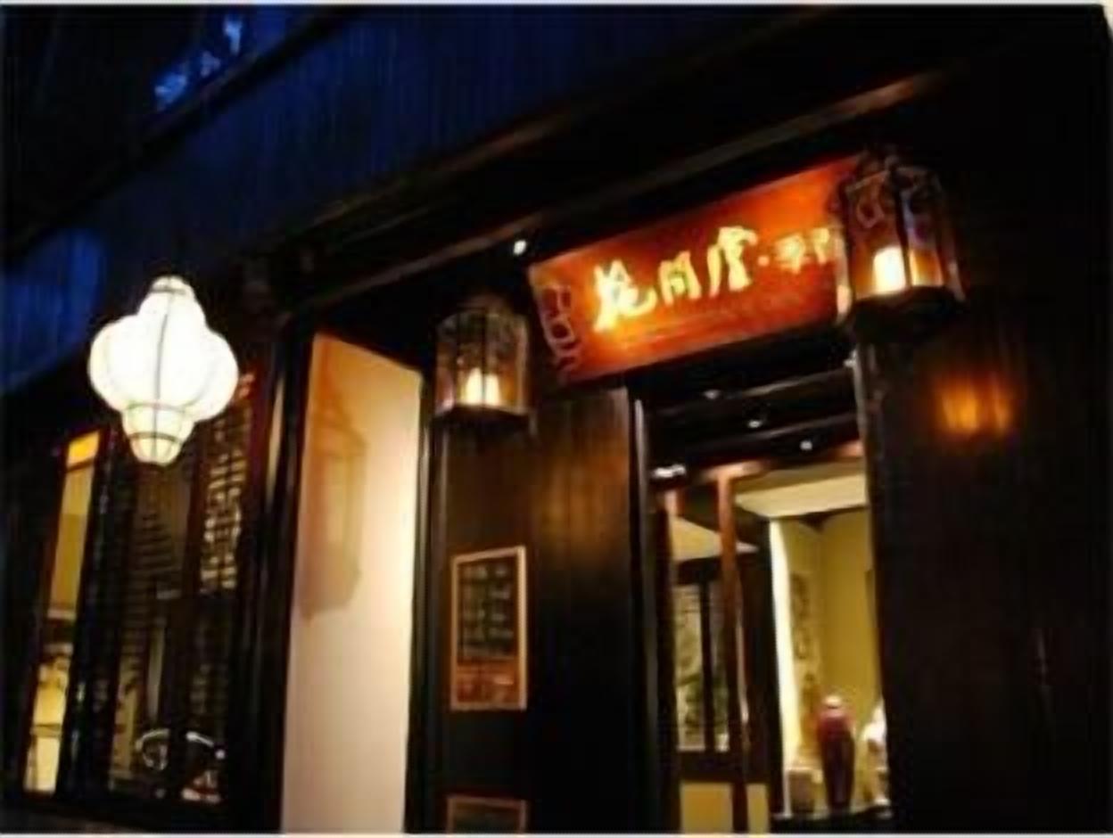 A traditional building with a signboard and a hanging light fixture.